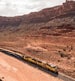 Train travelling through red rocks canyon