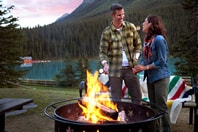 Couple cooking on a fire at Lake Louise
