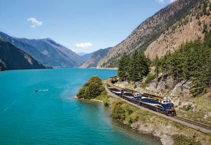 Train travelling along a glacial lake in the Rockies